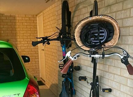 Two bikes parked in Steadyracks, sharing small garage space with a car.