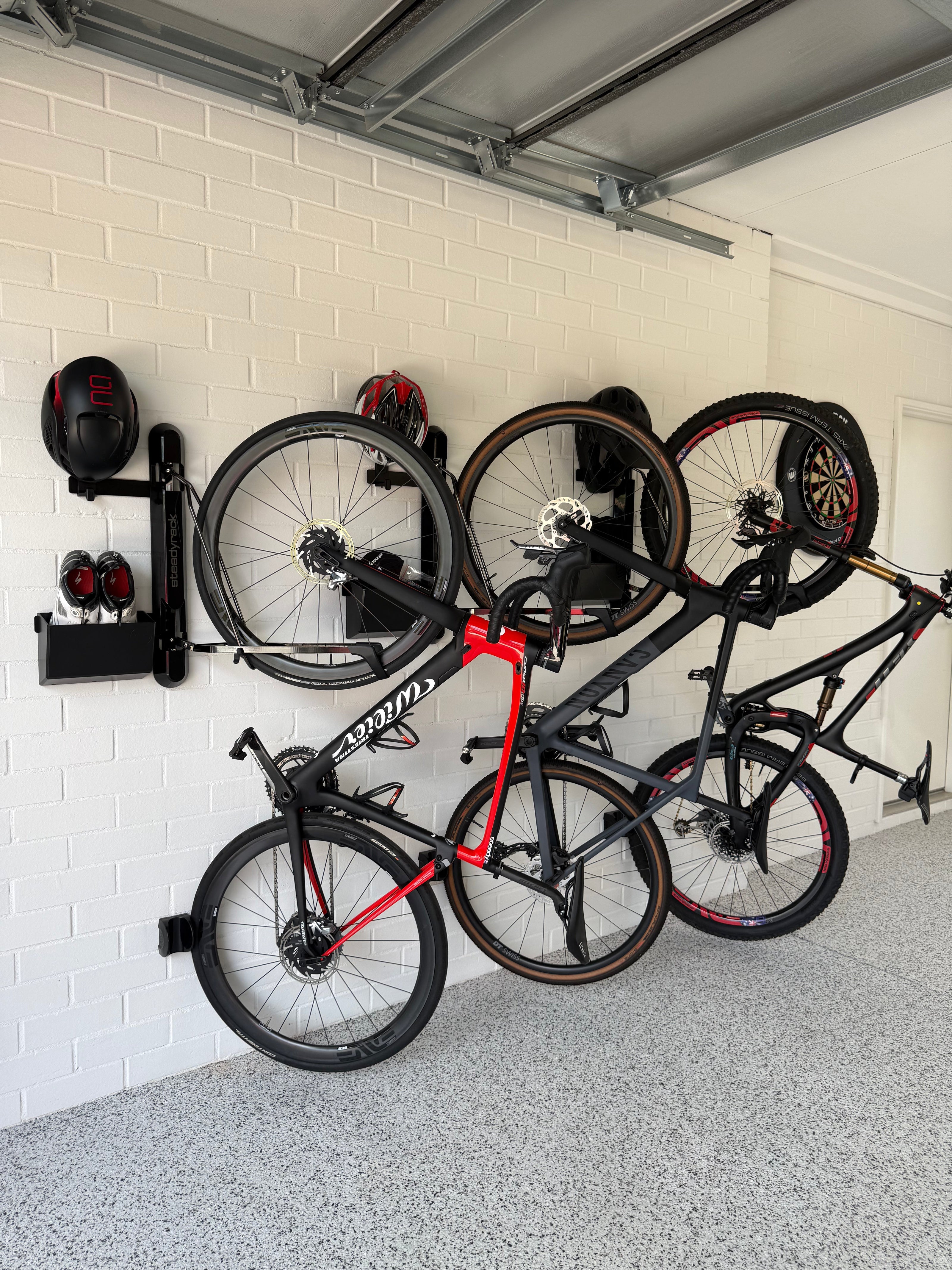 Bikes stored in wall mount bike racks in a garage. 