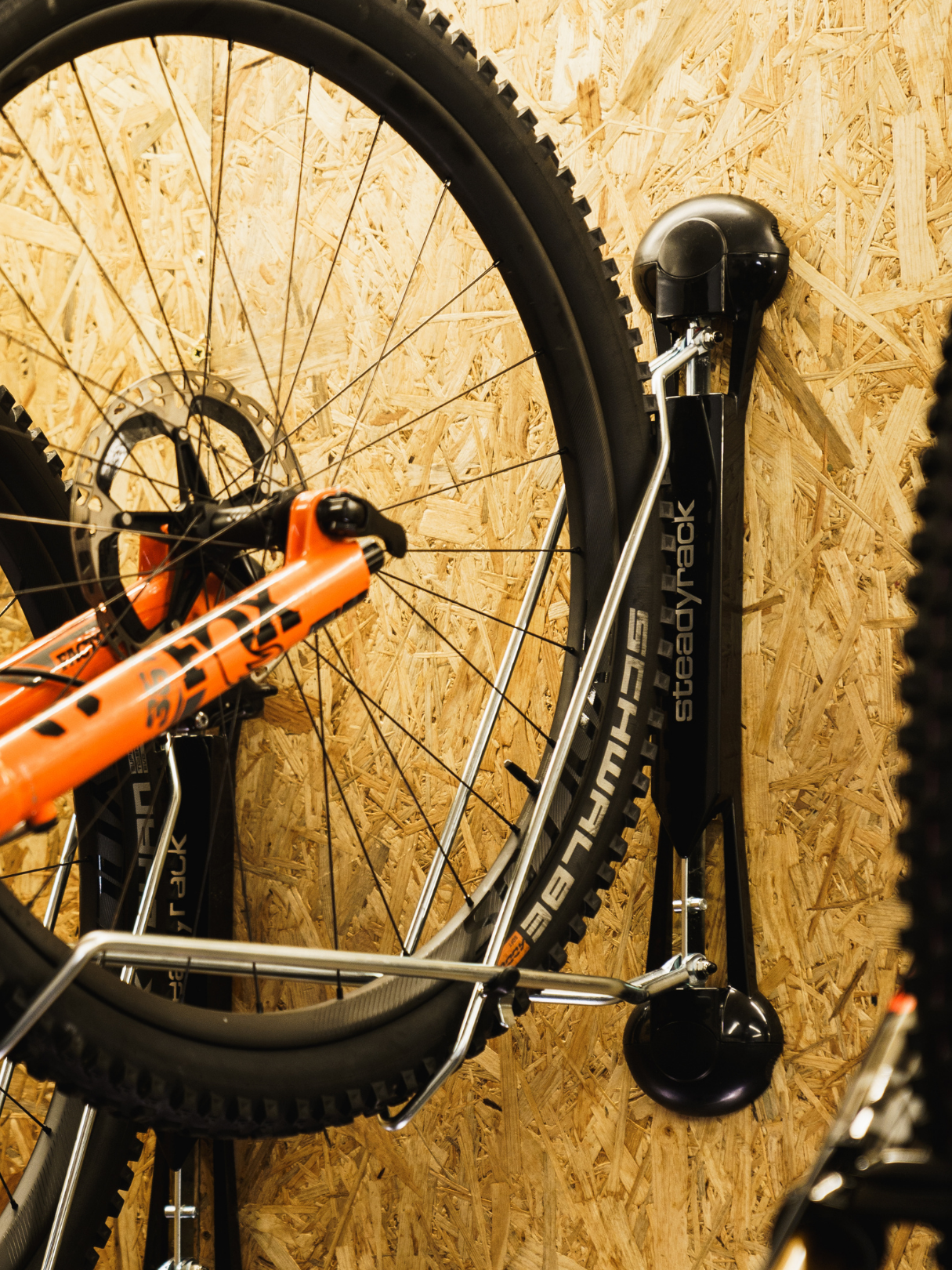 Bicycle mounted on a wall bracket against a wooden panel background