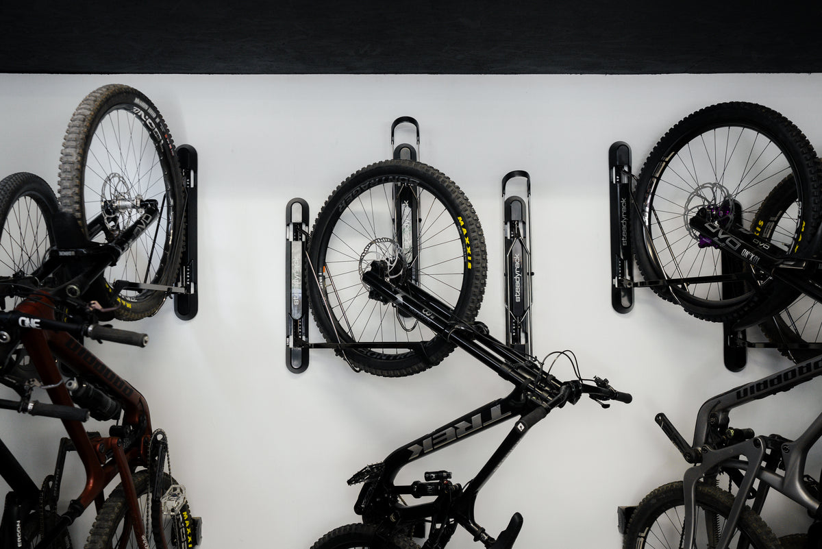 Bicycles mounted on a wall-mounted bike rack against a white background