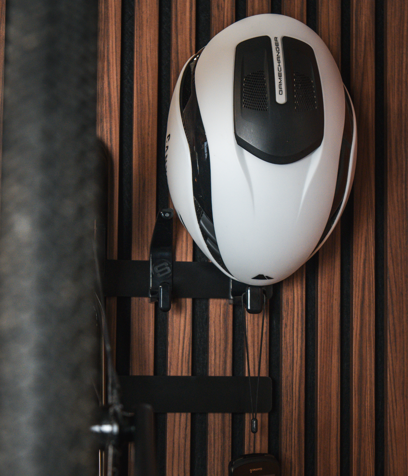 A black and white helmet with a wooden background. 