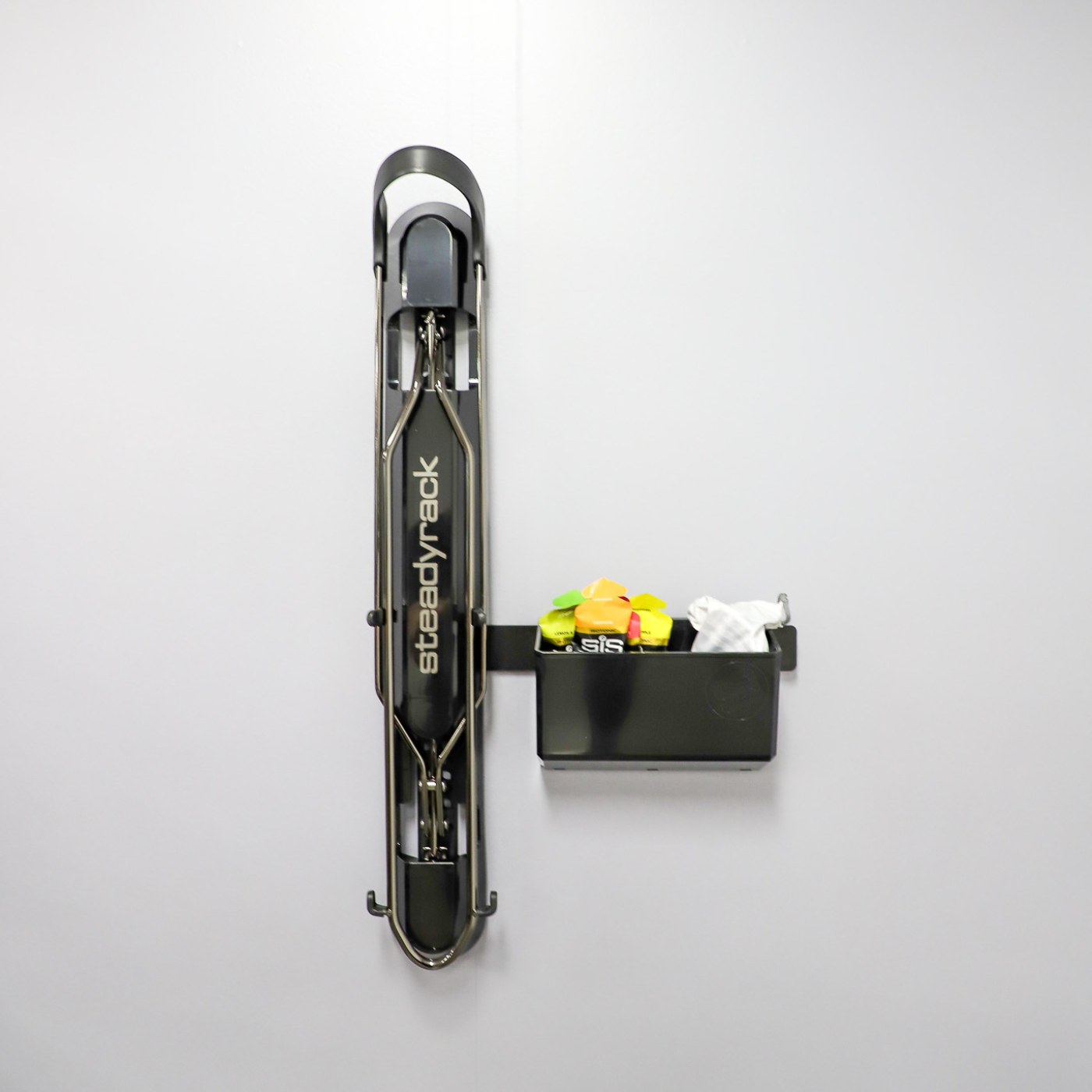 A ProFlex Rack with the GearMate SteadyBin attached storing a sunglasses in a case and energy gels. 