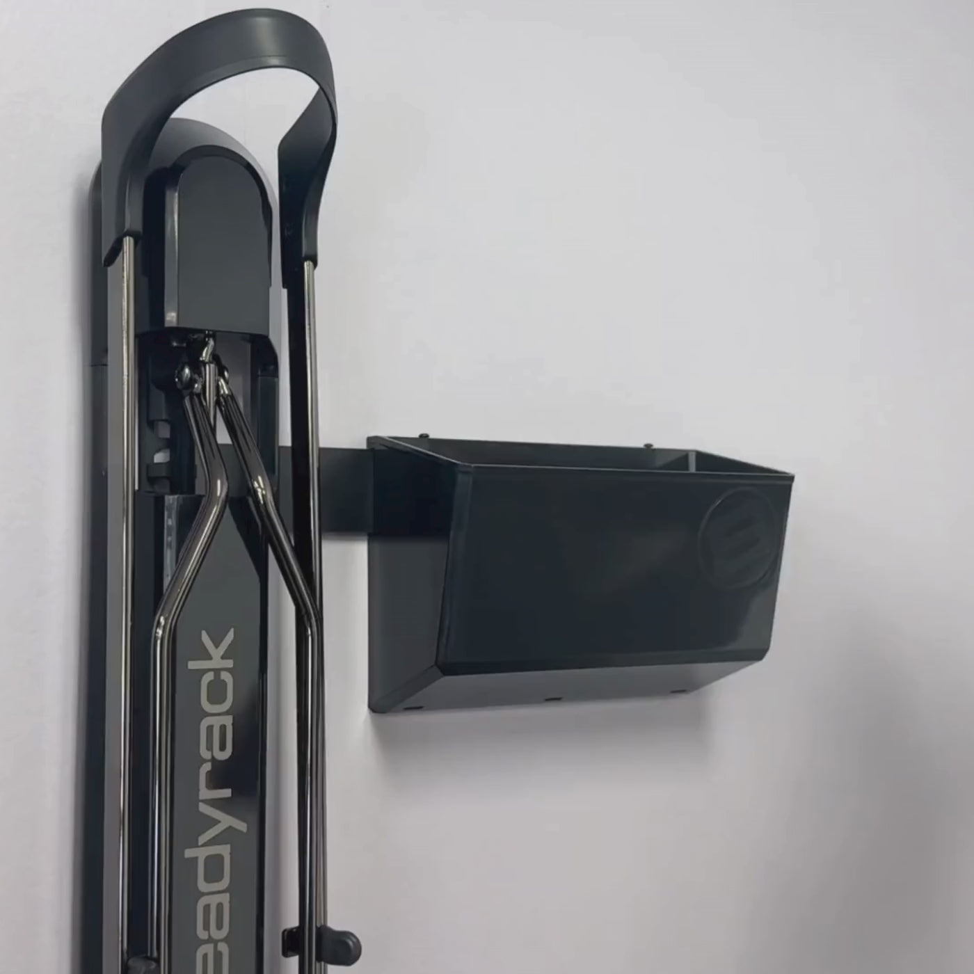 A person placing energy gels into a GearMate Medium SteadyBin attached with a bracket to a bike rack. 