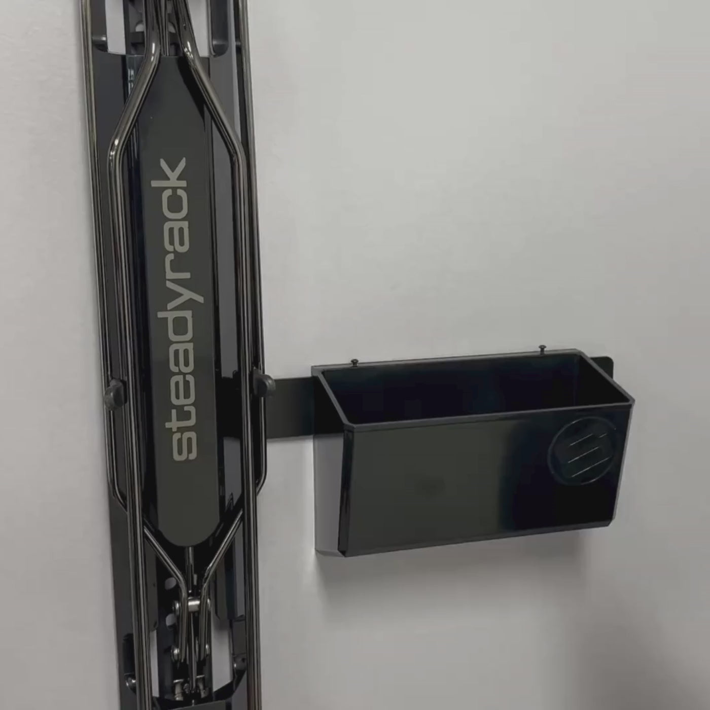 A person storing energy gels and sunglasses in a case in a black GearMate bin component. 